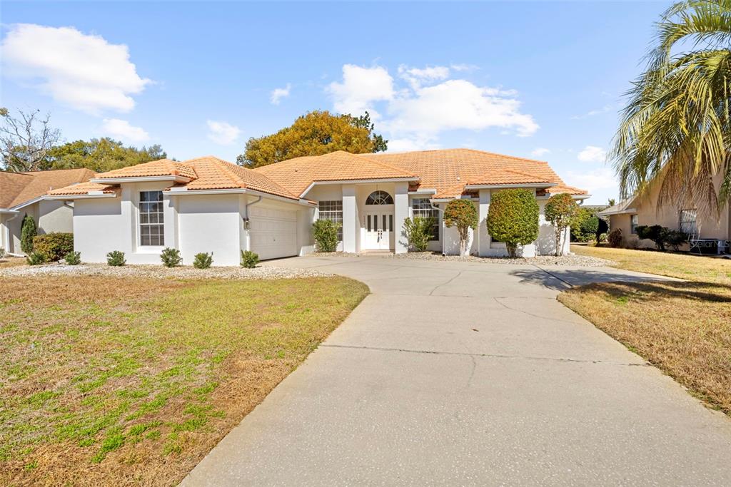 9369 Ashley Drive Weeki Wachee, FL 34613 - Photo 58 of 80 a front view of a house with a garden