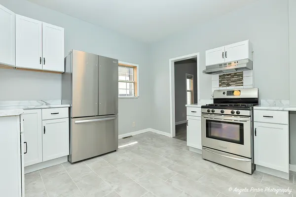 a kitchen with appliances a refrigerator and cabinets