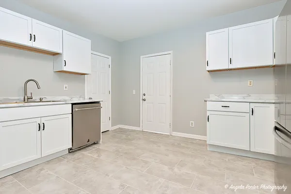 a kitchen with white cabinets stainless steel appliances and sink