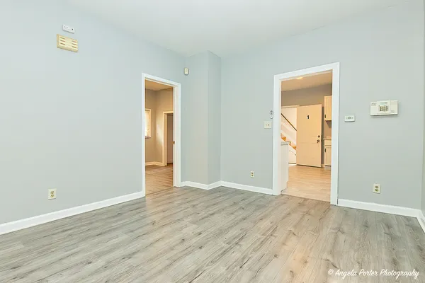 a view of an empty room with wooden floor