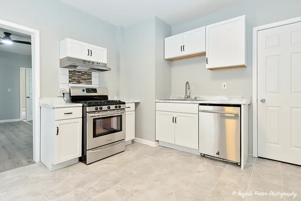 a kitchen with white cabinets and white appliances