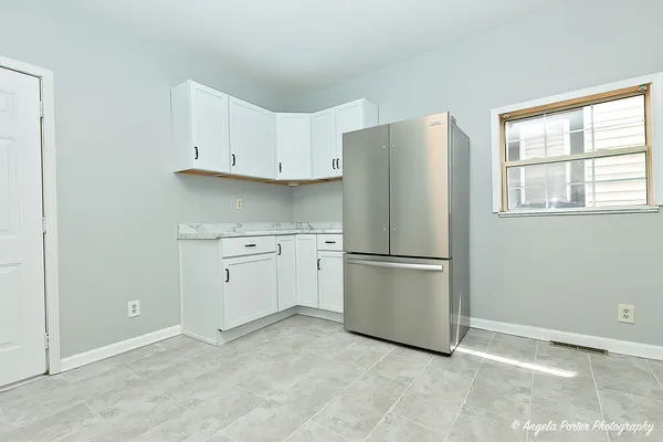 a kitchen with a refrigerator sink and cabinets