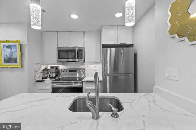 a kitchen with a sink a microwave a refrigerator and cabinets