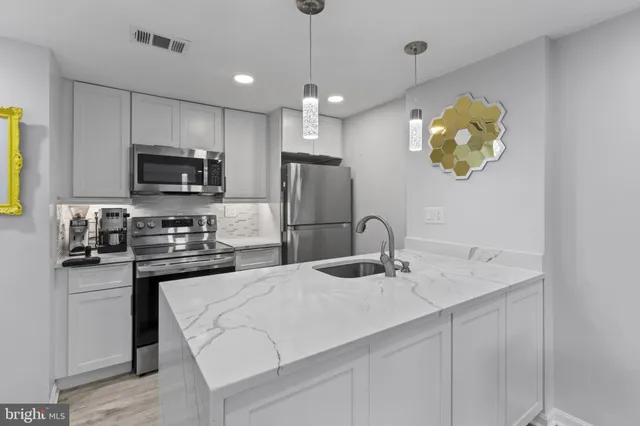 a kitchen with a sink appliances and cabinets
