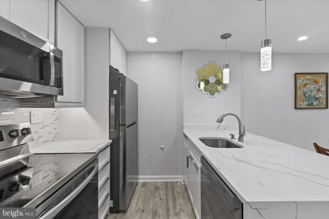 a kitchen with stainless steel appliances a sink a stove and cabinets