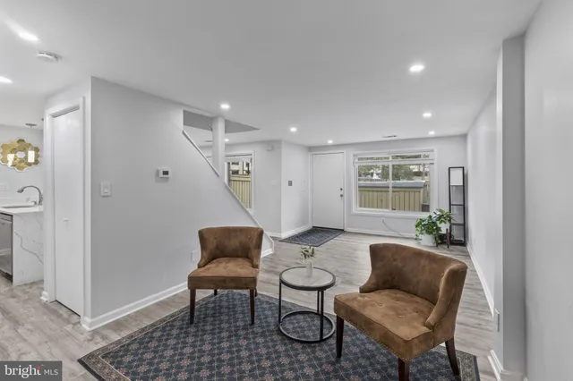 a kitchen with stainless steel appliances granite countertop a sink a refrigerator and a dining table with wooden floor