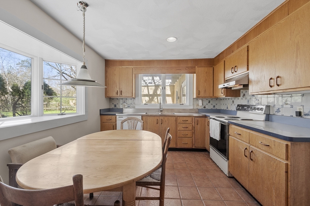 229 Musketaquid Road Concord, MA 01742 - Photo 15 of 21 a kitchen with a table chairs sink and cabinets