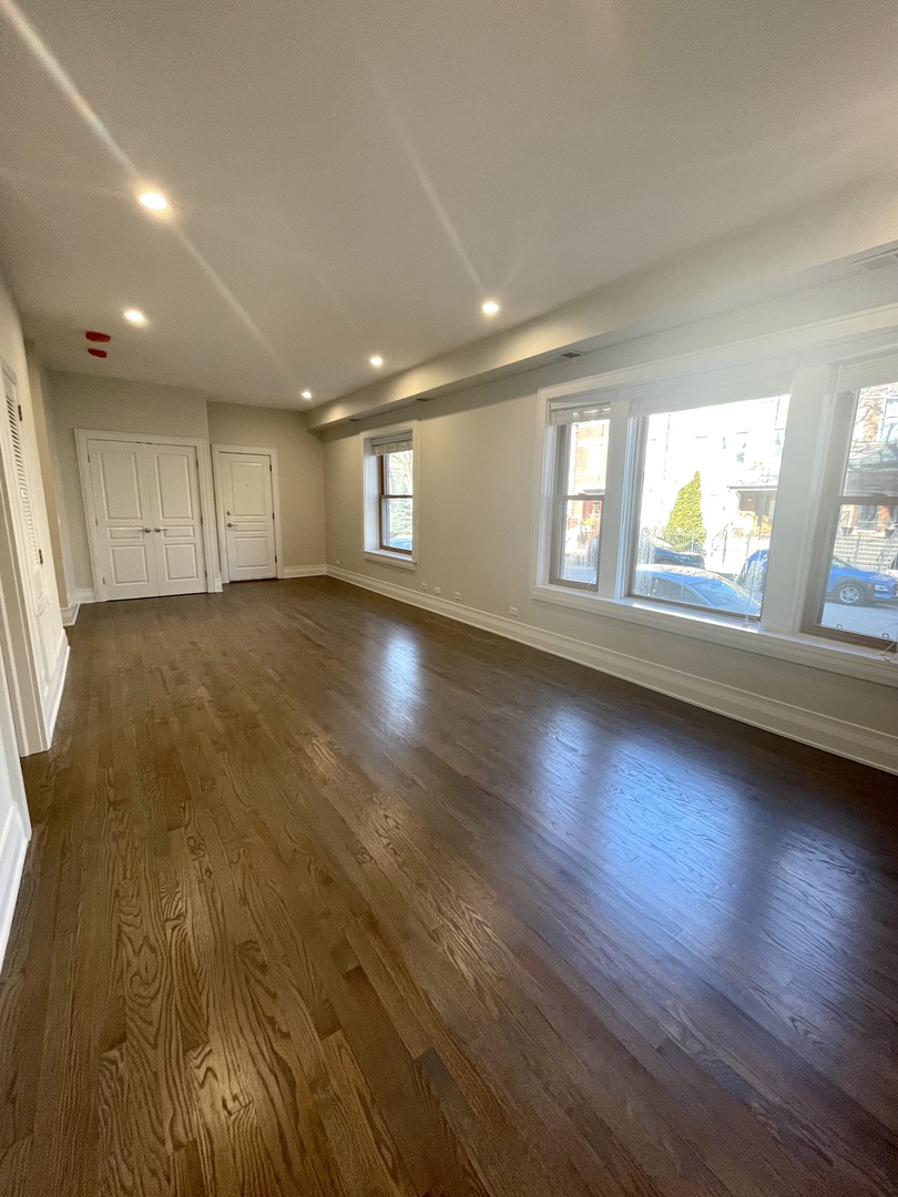 2539 West Iowa Street, Unit 1 Chicago, IL 60622 - Photo 3 of 19 an empty room with wooden floor and windows