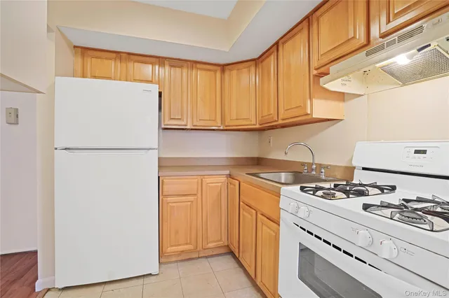 a kitchen with stainless steel appliances granite countertop a refrigerator and a stove