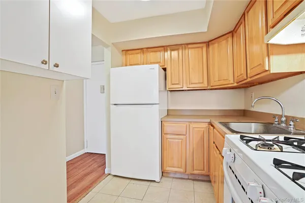 a kitchen with a refrigerator sink and cabinets
