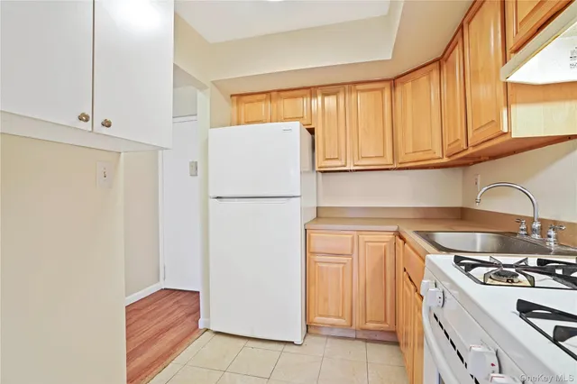 a kitchen with a refrigerator sink and cabinets