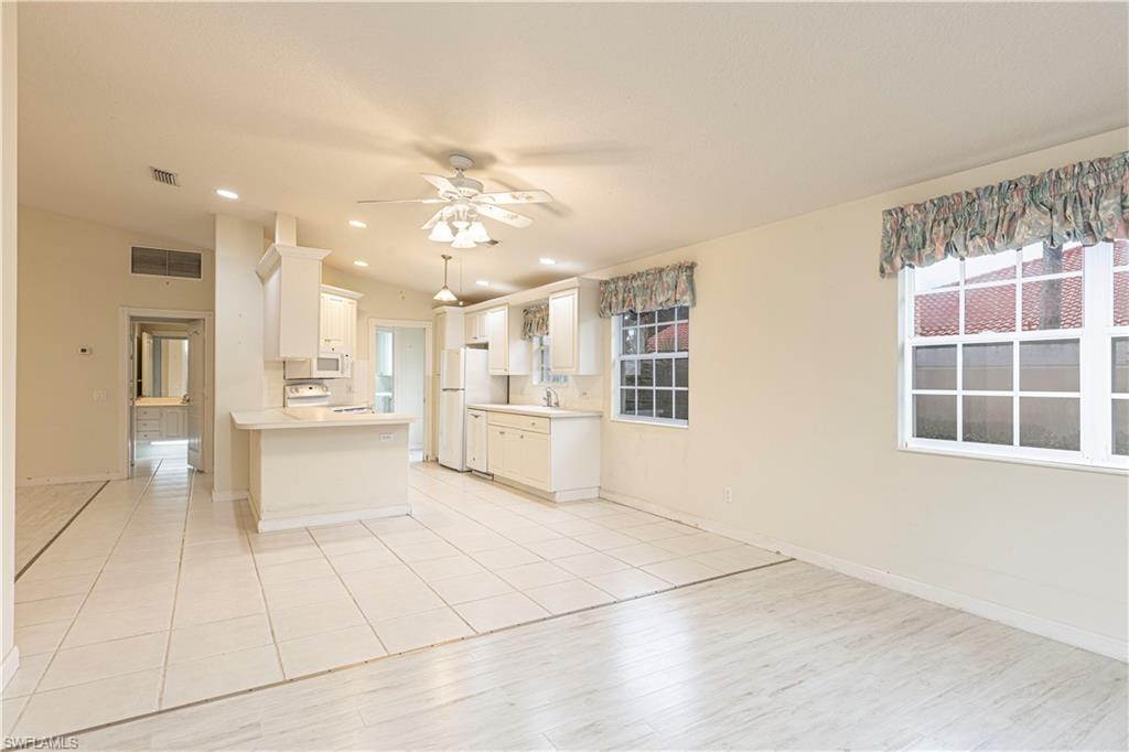 4187 St George Lane Naples, FL 34119 - Photo 12 of 33 a view of an empty room with kitchen and window