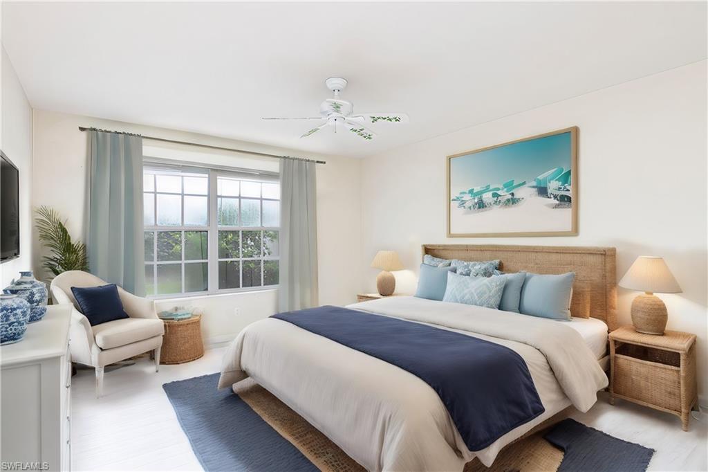 4187 St George Lane Naples, FL 34119 - Photo 13 of 33 a spacious bedroom with a bed couch and a large window
