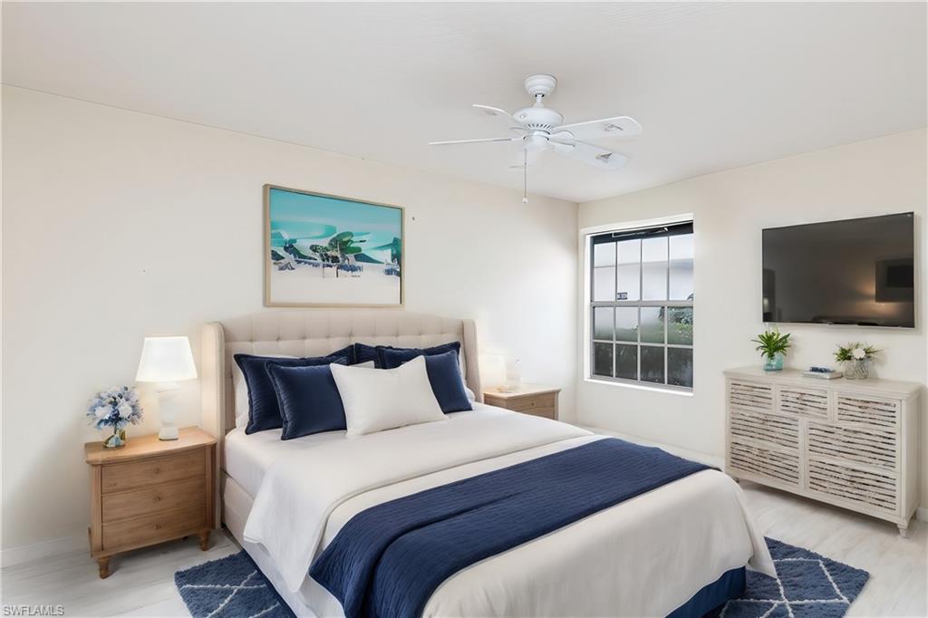 4187 St George Lane Naples, FL 34119 - Photo 17 of 33 a bedroom with a bed and a flat screen tv