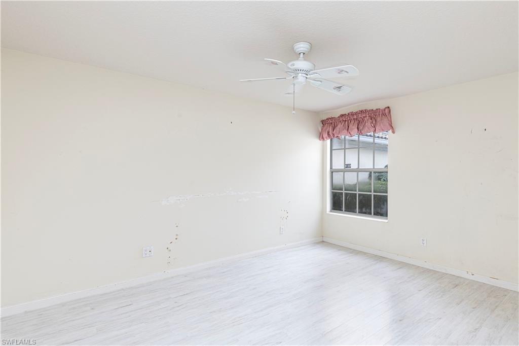 4187 St George Lane Naples, FL 34119 - Photo 18 of 33 an empty room with chandelier fan and windows