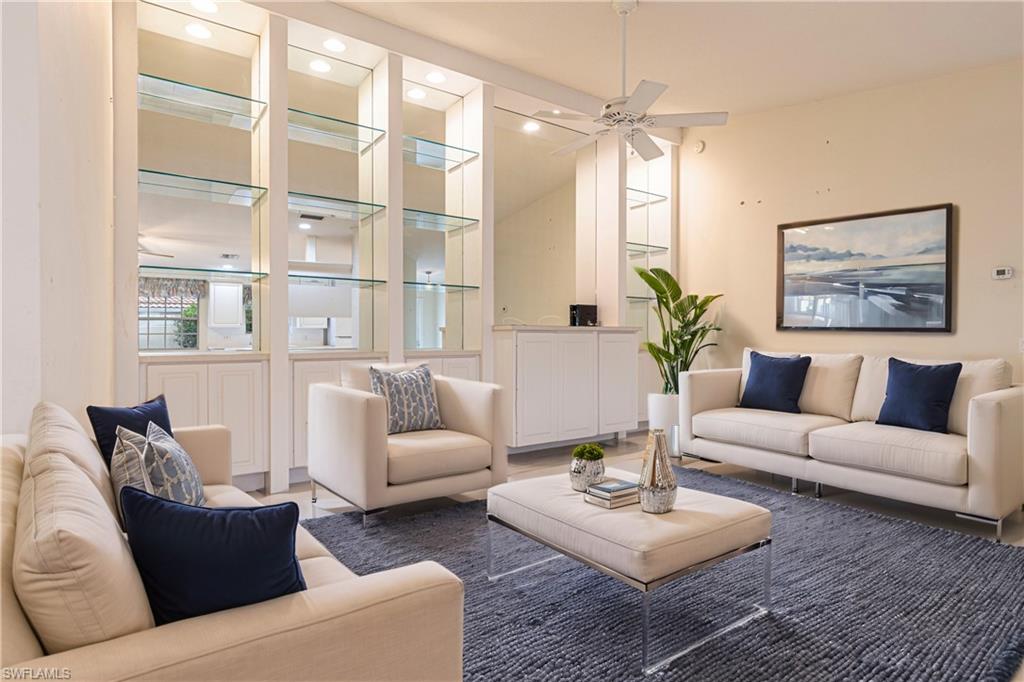 4187 St George Lane Naples, FL 34119 - Photo 2 of 33 a living room with furniture a table and a large window
