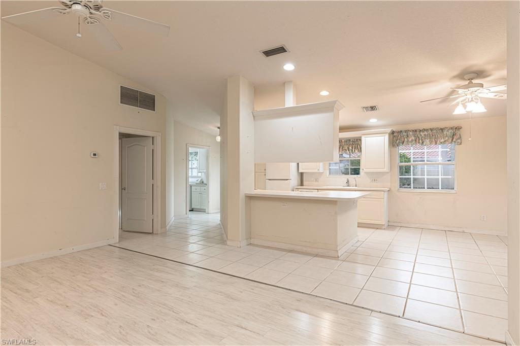 4187 St George Lane Naples, FL 34119 - Photo 8 of 33 a large kitchen with granite countertop a large counter top space a sink stainless steel appliances and cabinets