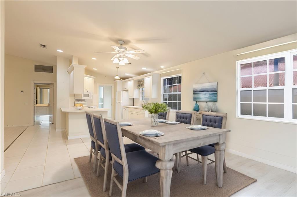 4187 St George Lane Naples, FL 34119 - Photo 9 of 33 a view of a dining room with furniture and a large window