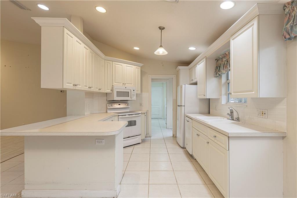 4187 St George Lane Naples, FL 34119 - Photo 10 of 33 a kitchen with stainless steel appliances kitchen island granite countertop a sink and cabinets