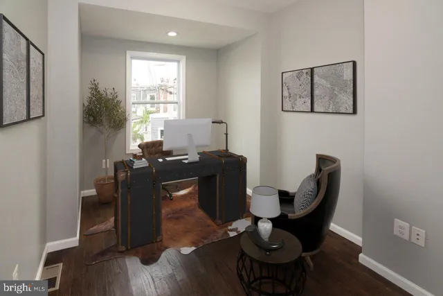 a view of a workspace with furniture and a window