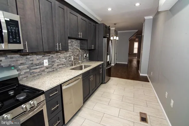 a kitchen with stainless steel appliances granite countertop a sink stove and cabinets