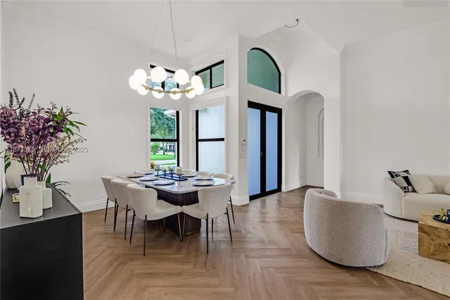 a dining room with furniture potted plants and wooden floor