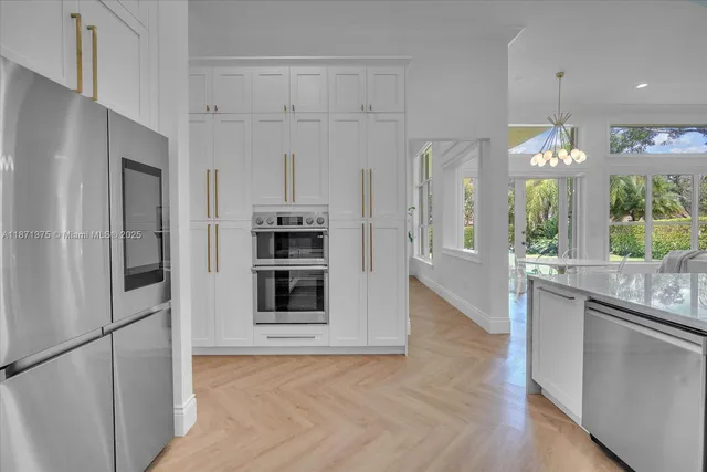 a kitchen with kitchen island a sink appliances and wooden floor