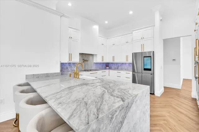 a kitchen with kitchen island a sink appliances and wooden floor