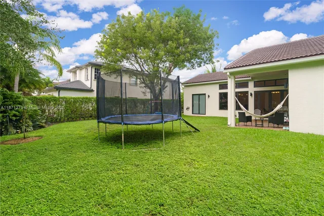 a view of a house with a yard and potted plants