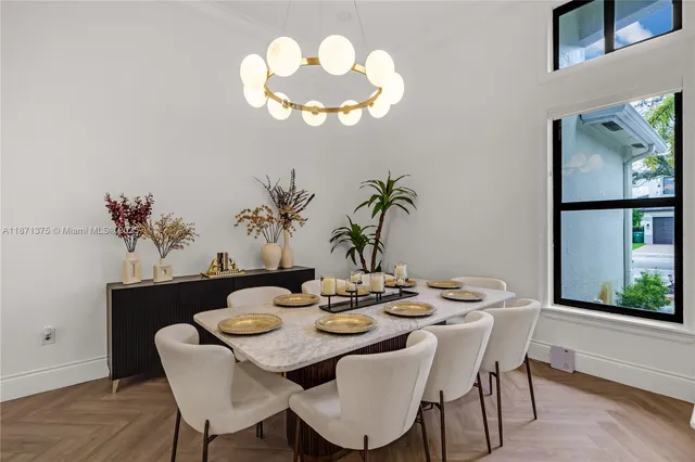 a view of a dining room with furniture a chandelier and wooden floor