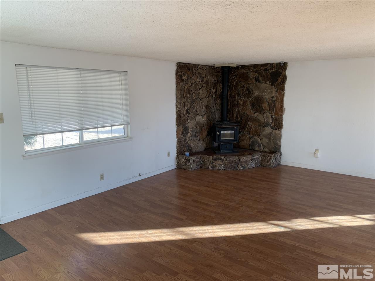 8579 Aquifer Way Reno, NV 89506 - Photo 6 of 17 a view of empty room with wooden floor and fan