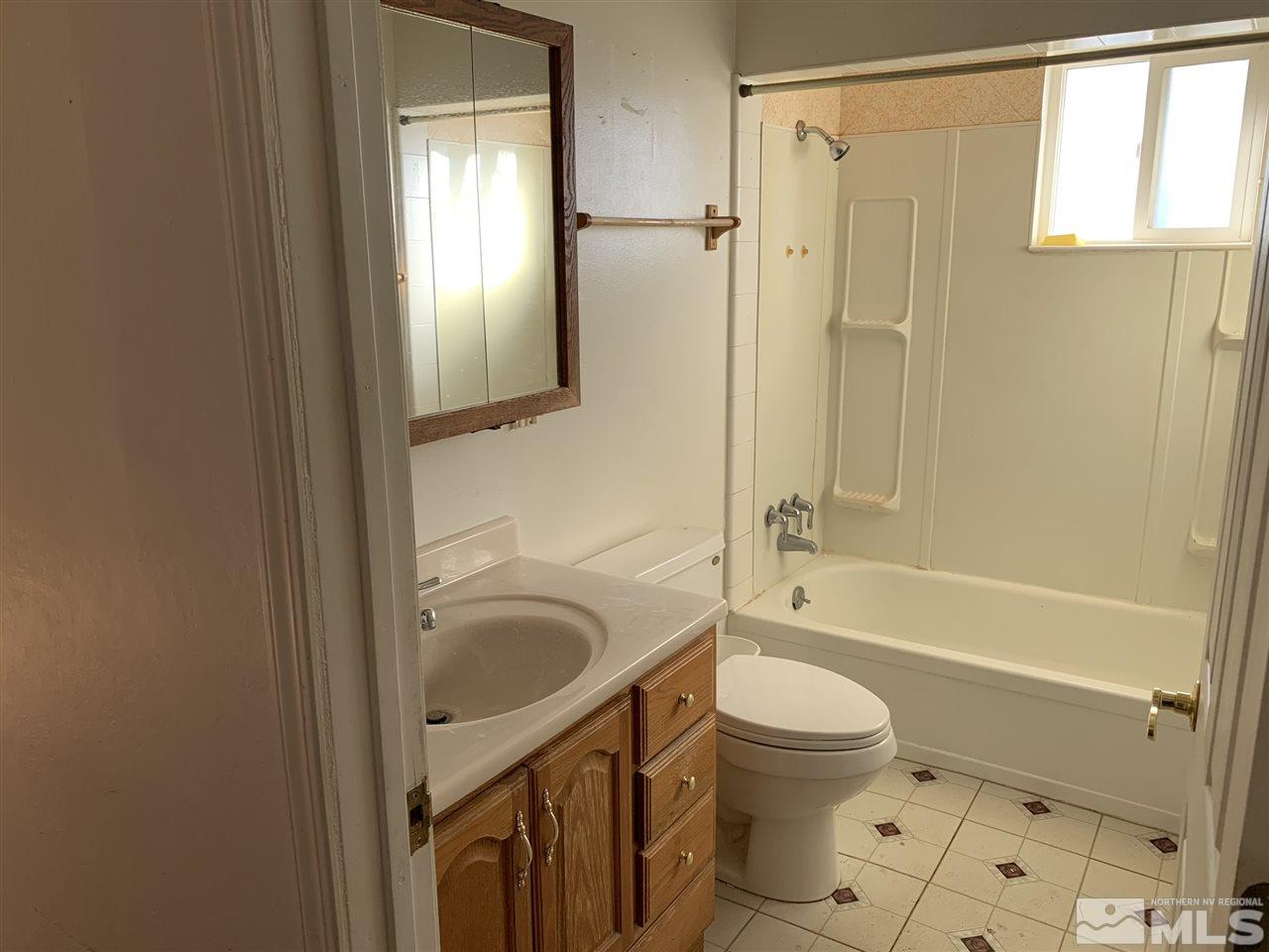 8579 Aquifer Way Reno, NV 89506 - Photo 8 of 17 a bathroom with a granite countertop toilet sink and shower