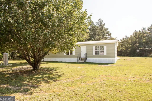 a view of a house with backyard and tree