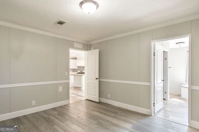a view of empty room with wooden floor