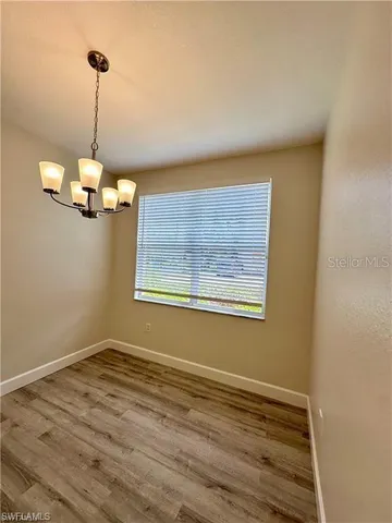 a kitchen with stainless steel appliances granite countertop a sink a microwave oven a refrigerator and white cabinets with wooden floor