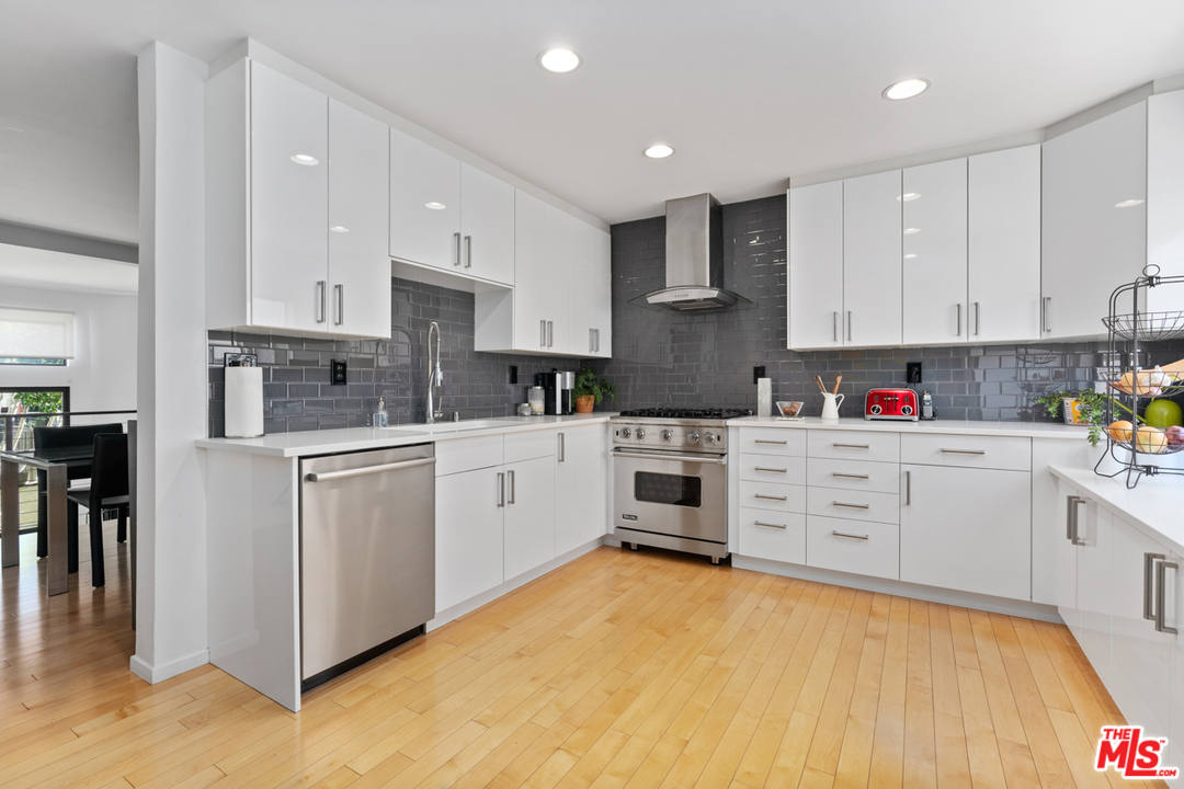a kitchen with white cabinets stainless steel appliances and sink