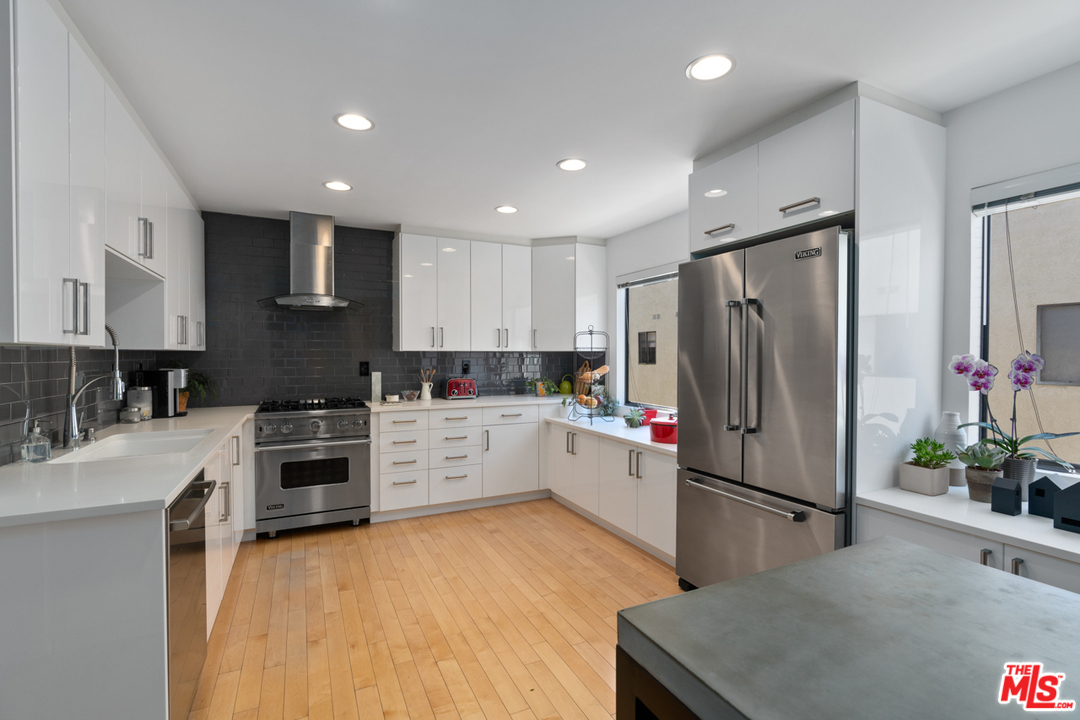 19355 Sherman Way, Unit 33 Reseda, CA 91335 - Photo 2 of 22 a kitchen with refrigerator a sink and white cabinets