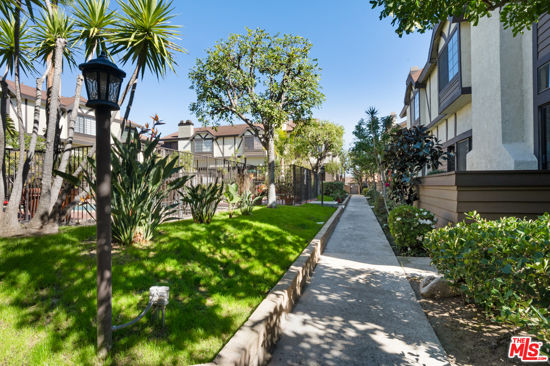 19355 Sherman Way, Unit 33 Reseda, CA 91335 - Photo 20 of 22 a view of a yard with plants and palm trees