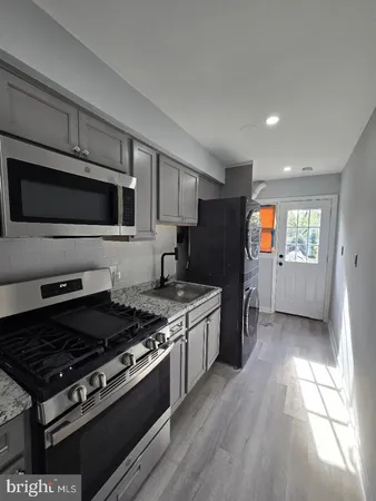 a kitchen with stainless steel appliances granite countertop a stove a sink and a microwave