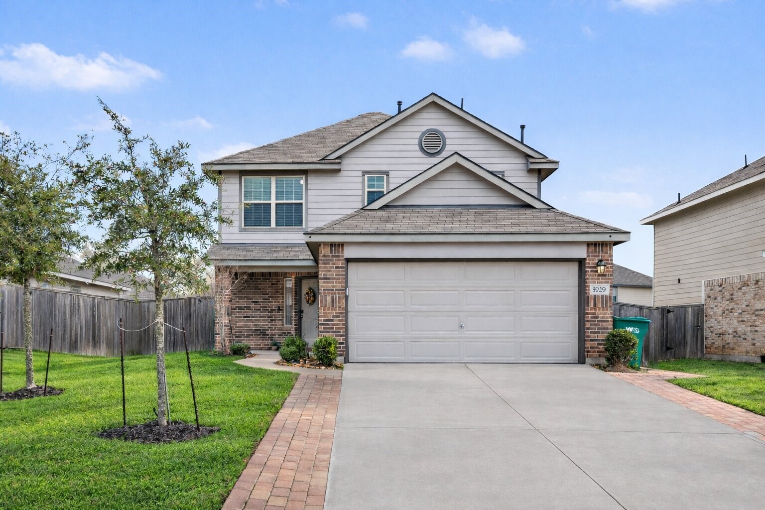 Striking curb appeal highlighted by decorative paver accents that add character and dimension to the front elevation. Photo enhanced for grass color only.