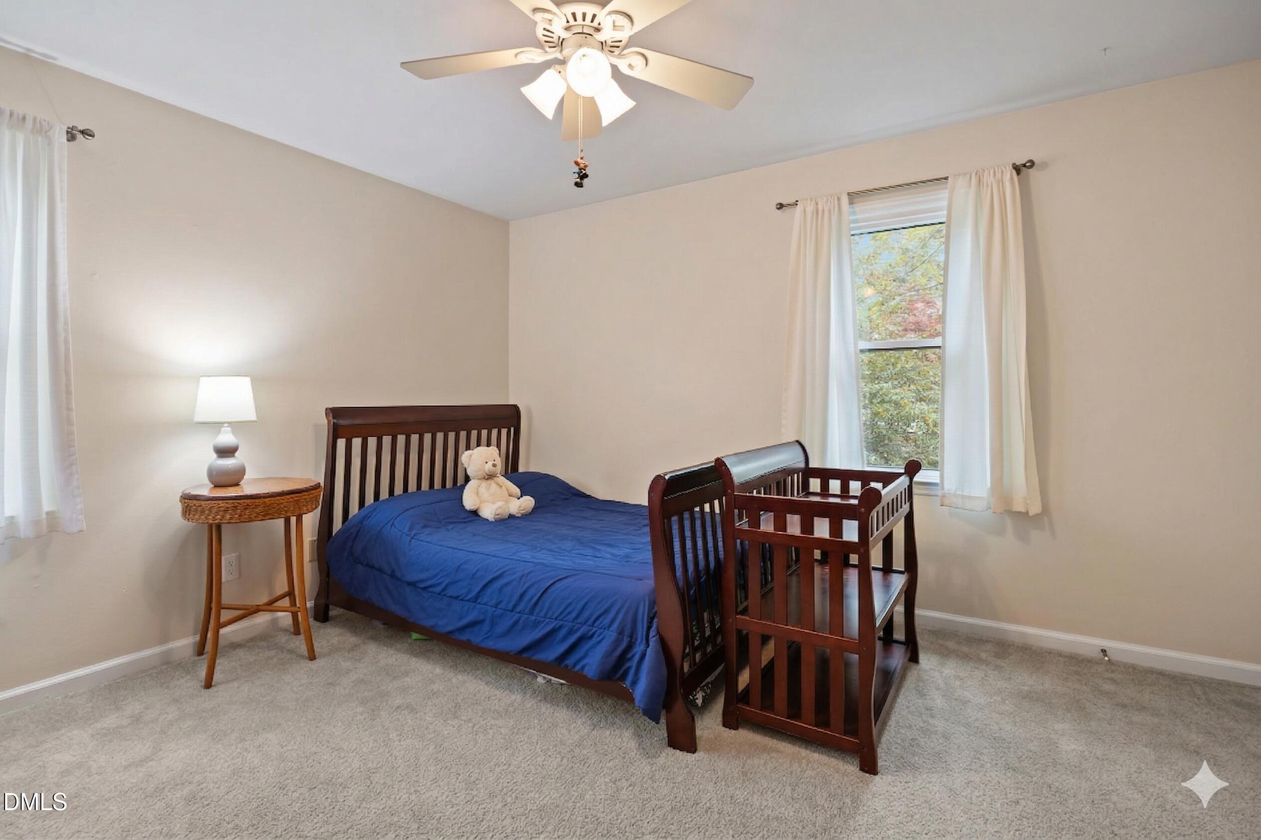 212 Esquire Lane Cary, NC 27513 - Photo 18 of 31 a bedroom with a bed and a chandelier
