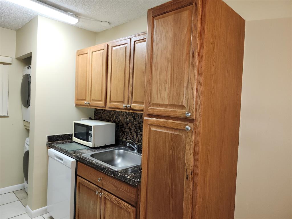 545 Trace Circle, Unit 105 Deerfield Beach, FL 33441 - Photo 11 of 44 a kitchen with a refrigerator and cabinets