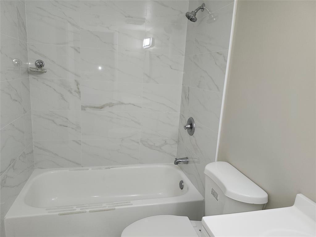 545 Trace Circle, Unit 105 Deerfield Beach, FL 33441 - Photo 23 of 44 a bathroom with a toilet and bathtub