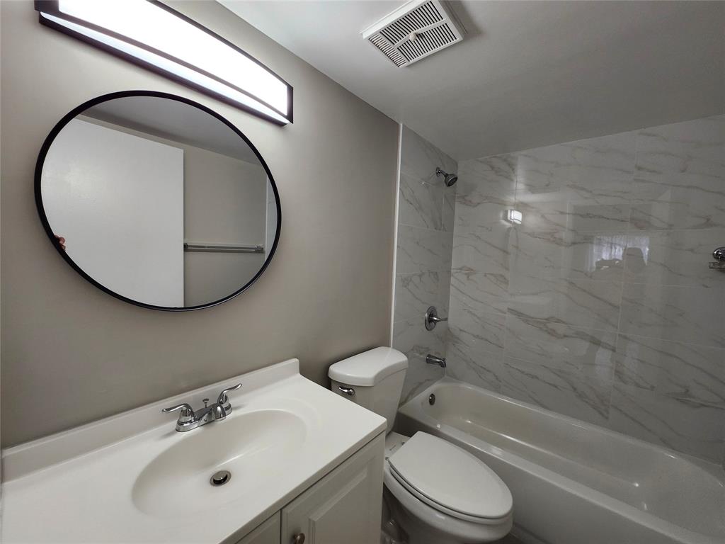 545 Trace Circle, Unit 105 Deerfield Beach, FL 33441 - Photo 29 of 44 a bathroom with a sink a toilet and a mirror