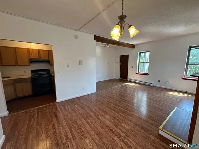 a view of a kitchen with a stove wooden cabinets and a wooden floor