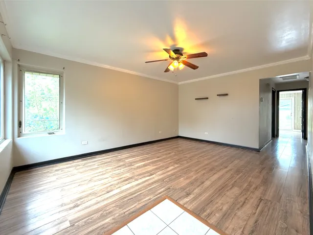 a view of an empty room and window with wooden floor