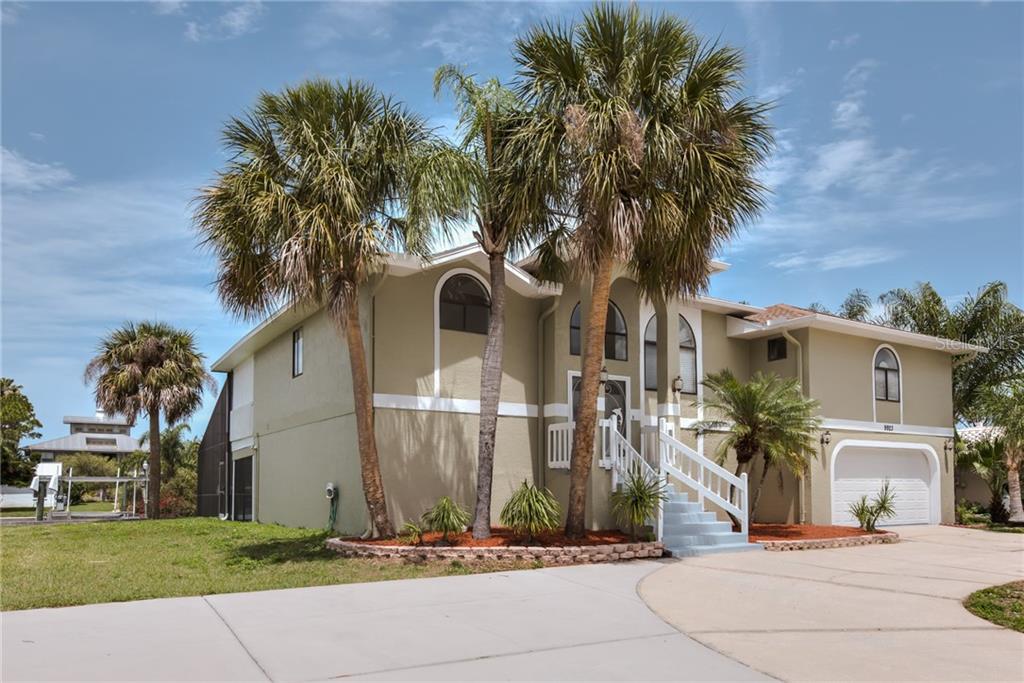 9923 San Sebastian Way Port Richey, FL 34668 - Photo 1 of 1 a front view of a house with a yard and potted plants