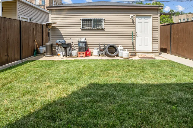 a backyard of a house with table and chairs