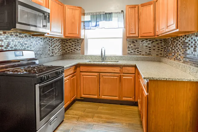 a kitchen with granite countertop a sink a stove and cabinets