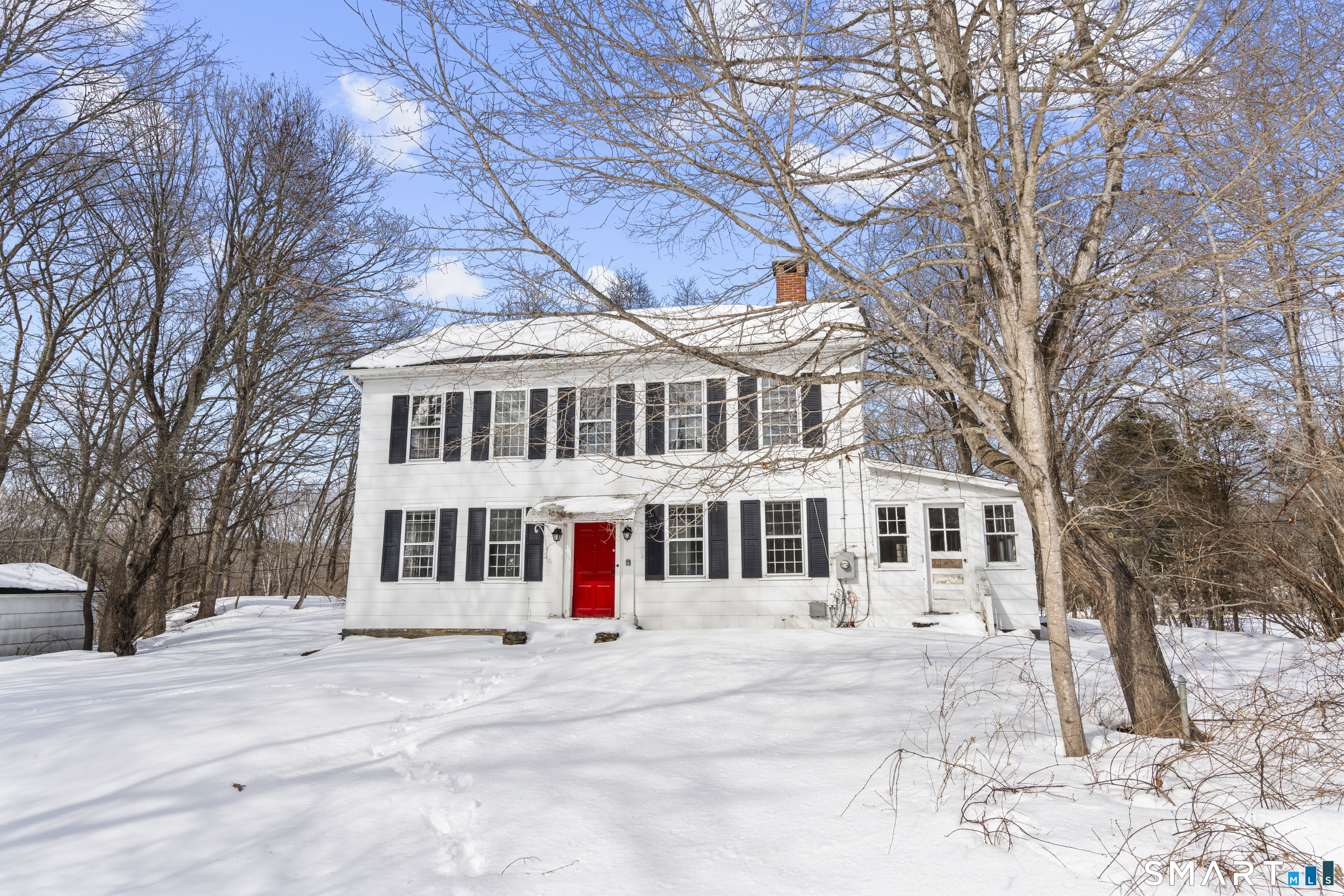 a front view of a building with lot of trees